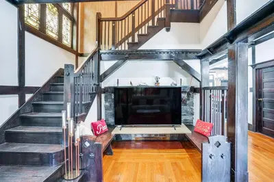 a living room with a staircase and a large tv at Steps to Union College Home with Shared Yard! in Schenectady