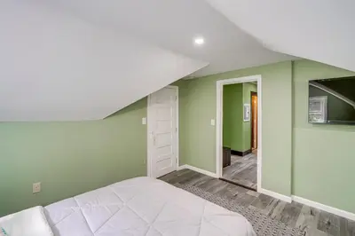a bedroom with green walls and a white bed at Walk to Nott Memorial Studious Retreat Near Eats in Schenectady