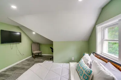 a bedroom with green walls and a couch and a tv at Walk to Nott Memorial Studious Retreat Near Eats in Schenectady