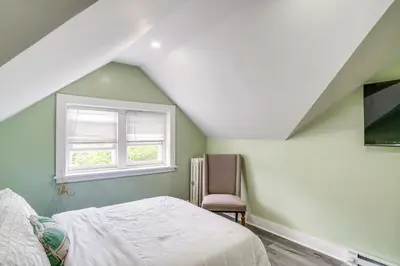a bedroom with a bed and a window and a chair at Walk to Nott Memorial Studious Retreat Near Eats in Schenectady