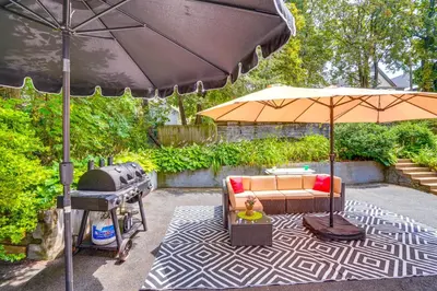 a patio with a couch and an umbrella and a grill at Walk to Nott Memorial Studious Retreat Near Eats in Schenectady