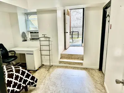 an empty room with a desk and a desk chair at 2 Bedroom Apt in LIC, Private WITH BACKYARD ! in Roosevelt Island