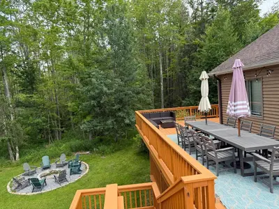 a deck with a table and chairs and an umbrella at Mountain Modern Escape - EV Charger - 5BDRM in Hensonville