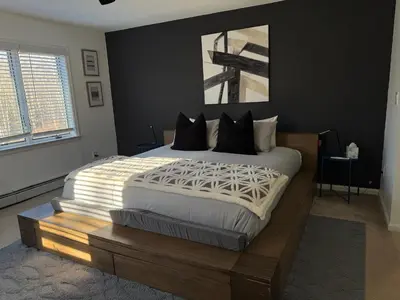 a bedroom with a large bed with a wooden headboard at Mountain Modern Escape - EV Charger - 5BDRM in Hensonville