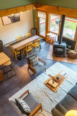 a living room with a table and a wood stove at MtSnow , HotTub, Pool, Air Hockey,Ping Pong, Darts in Wilmington