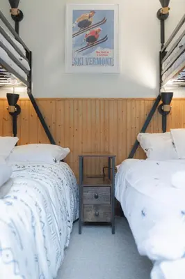 two beds in a room with a table between them at MtSnow , HotTub, Pool, Air Hockey,Ping Pong, Darts in Wilmington