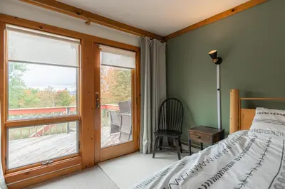 a bedroom with a bed and a sliding glass door at MtSnow , HotTub, Pool, Air Hockey,Ping Pong, Darts in Wilmington