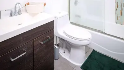 a bathroom with a white toilet and a sink at Spacious 3BR Retreat Near Times Square in New York