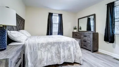 a bedroom with a bed and a dresser and a mirror at Family Retreat Near Yale - Stylish Free Wifi in New Haven