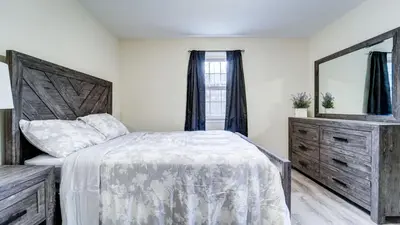 a bedroom with a bed and a dresser and a mirror at Family Retreat Near Yale - Stylish Free Wifi in New Haven