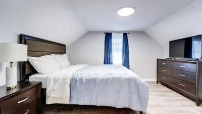 a bedroom with a bed and a dresser and a television at Family Retreat Near Yale - Stylish Free Wifi in New Haven
