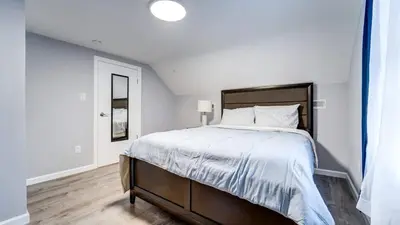 a white bedroom with a large bed and a window at Family Retreat Near Yale - Stylish Free Wifi in New Haven