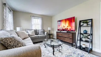 a living room with a couch and a tv at Family Retreat Near Yale - Stylish Free Wifi in New Haven