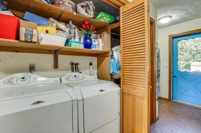 a washing machine in a laundry room with a blue door at Family Getaway in Bristol Near Trails and Parks! in Bristol