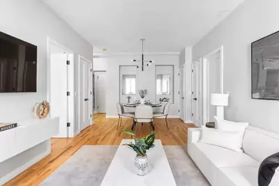 a white living room with a white couch and a table at Top Notch 2BR & 2BA Suite Minutes to Central Park in New York