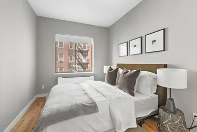 a bedroom with a white bed and a window at Top Notch 2BR & 2BA Suite Minutes to Central Park in New York
