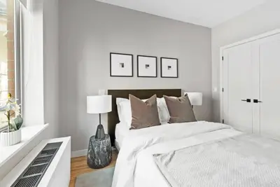 a white bedroom with a large bed and a window at Top Notch 2BR & 2BA Suite Minutes to Central Park in New York
