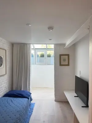 a bedroom with a bed and a television in it at Williamsburg Design Apartment in Brooklyn