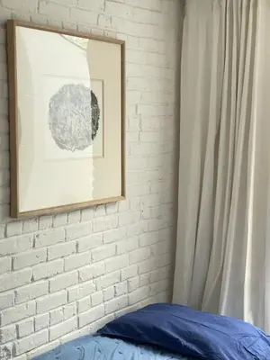 a bedroom with a white brick wall and a picture at Williamsburg Design Apartment in Brooklyn