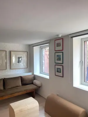 a living room with a couch and two windows at Williamsburg Design Apartment in Brooklyn