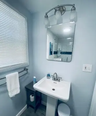 a white bathroom with a sink and a mirror at Dog-Friendly Oceanfront Getaway - Walk to Dining - Private Beach Access in Milford