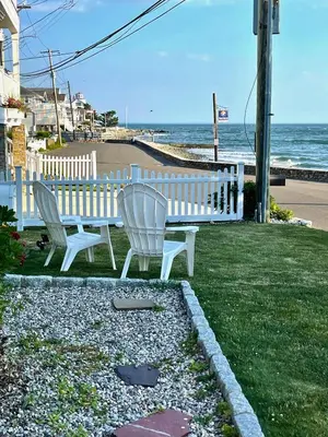 two white chairs sitting next to a bench near the ocean at Dog-Friendly Oceanfront Getaway - Walk to Dining - Private Beach Access in Milford