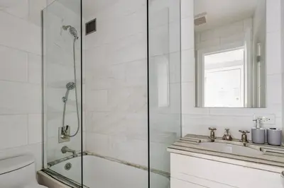 a white bathroom with a shower and a sink at Blueground Upper West Side fitness nr Central Park NYC-1932 in New York