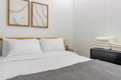 a bedroom with a bed with white sheets and pillows at Blueground Midtown West washerdryer nr Central Park NYC-1876 in New York