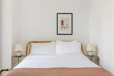 a bedroom with a white bed with two lamps at Blueground Midtown West washerdryer nr Central Park NYC-1876 in New York