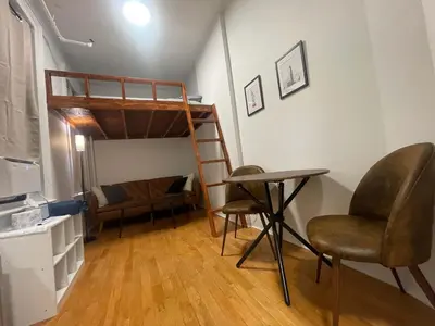 a room with a bunk bed and a desk and chairs at Renovated Studio in Union Square in New York