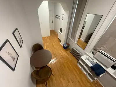 a living room with a table and a mirror at Renovated Studio in Union Square in New York
