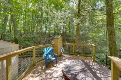 a deck with a blue chair and a bird house at Creek Dips and Smores Catskills Gem