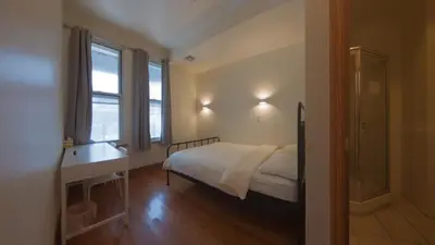 a bedroom with a bed and two windows at U.S. Pacific Hotel in New York
