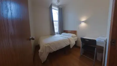 a small room with a bed and a window at U.S. Pacific Hotel in New York