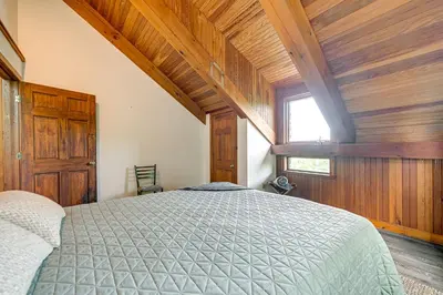 a bedroom with a bed and wooden walls and a window at Riverfront Hudson Valley Gem with Beach Access! in Athens