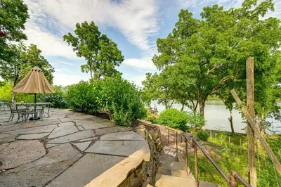a patio with a table and an umbrella at Riverfront Hudson Valley Gem with Beach Access! in Athens