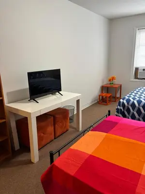 a room with a desk with a television and a bed at Room in New York in Jackson Heights