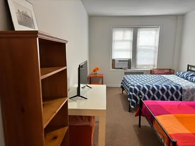 a bedroom with a bed and a desk with a computer at Room in New York in Jackson Heights