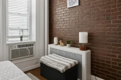 a living room with a brick wall and a stool at Heavenly Stays in New York