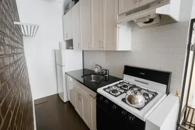a small kitchen with a stove and a sink at Heavenly Stays in New York