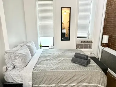 a bedroom with a bed with a suitcase on it at Heavenly Stays in New York