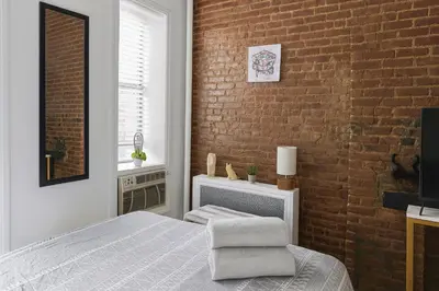a bedroom with a bed and a brick wall at Heavenly Stays in New York