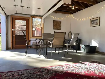 a dining room with chairs and a table and a rug at Green River Cottage in Guilford