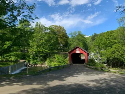 a red covered bridge over a road with a tunnel at Green River Cottage in Guilford