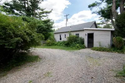 a small white house with a gravel driveway at Cozy Cottage on a Private Farm Nestled Among the Southern Catskill Mountains in Woodridge, New York in Woodridge