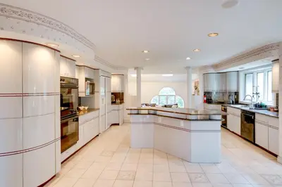 a large kitchen with white cabinets and appliances at Pool Table and Deck Luxury Mansion in Niskayuna! in Niskayuna