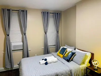a bedroom with a bed with two stuffed animals on it at Cozy 2BR Brick Haven! Near light rail! 35m to NYC in Jersey City