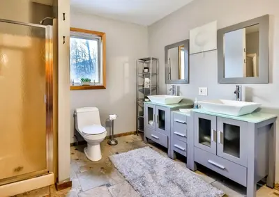 a bathroom with two sinks and a toilet at Triangle Tranquility Unique A Frame 6 BR Home in Lanesville