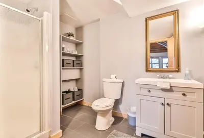 a white bathroom with a toilet and a mirror at Triangle Tranquility Unique A Frame 6 BR Home in Lanesville