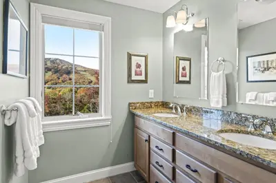 a bathroom with two sinks and a window at Escape to Mountainview Haven Spacious Retreat with Hot Tub at Mount Snow in West Dover